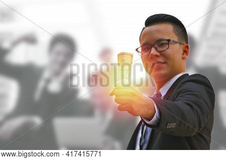 American Dollar Bank Note In Business Hand Put On Gray Suit  With Blur Picture Of Workers . Business