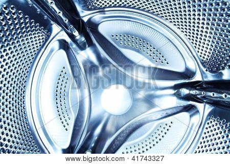 Perspective inside view into blue washing machine drum moving in fast and quick traffic motion blur