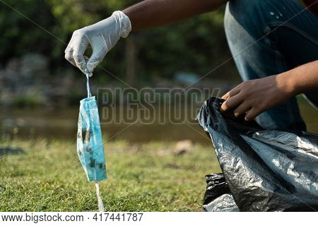 Focus On Hand With Gloves, Close Up Of Frontline Worker Hands Collecting Face Mask And Placing Insid