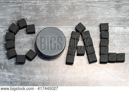 The Word Lumps Of Coal Laid Out On A Gray Background By Cubes With A Jar Of Charcoal Black Cream