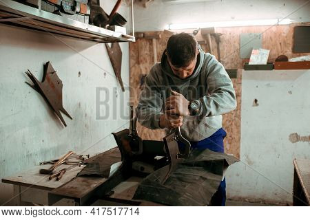 Tinsmith Blacksmith Use Hammer Working In His Workshop. Blacksmiths Workshop. Young Tinsmith In His 