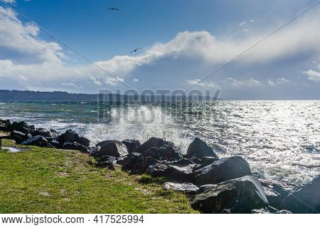 Back Rocks Lin The Shore On A Windy Day At Satlwater State Park In Washington State.