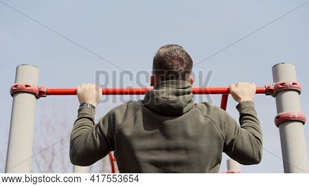 A Strong Guy Pulls Himself Up On A Horizontal Bar. A Man Pulls Himself Up On A Horizontal Bar In The