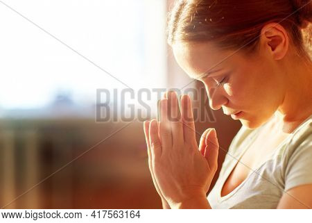 religion, faith and people concept - close up of woman meditating at yoga studio