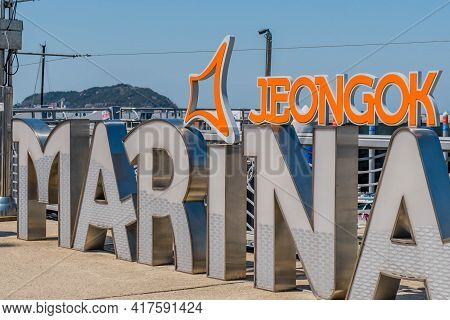 Pyeongtaek, South Korea; April 14, 2021: Jeongok Marina Sign On Walkway With Blue Sky In Background.