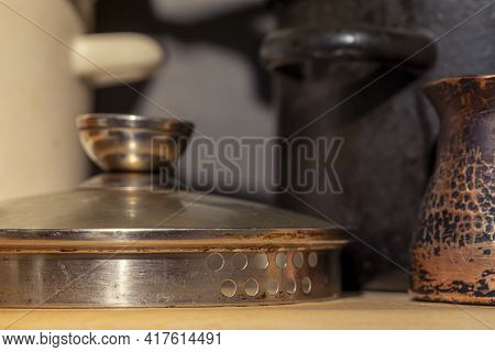 Kitchen Shelf With Kitchen Utensils. Pots, Pot Lid And Copper Coffee Pot