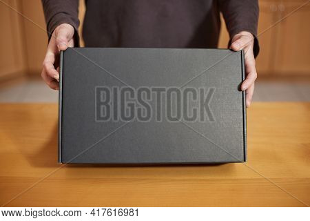 Shop assistant showing a blank black box of computer hardware equipment for buying, distributor office