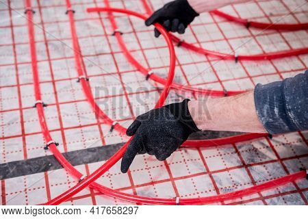 Pipefitter Install System Of Underfloor Heating System At Home
