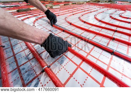 Pipefitter Install System Of Underfloor Heating System At Home