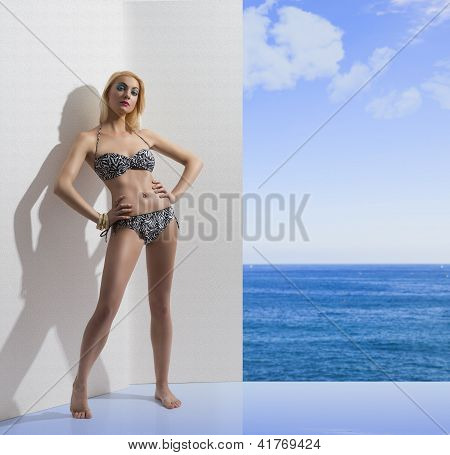 blonde MÃ¤dchen im Bikini in der NÃ¤he der Wand mit den HÃ¤nden auf den HÃ¼ften