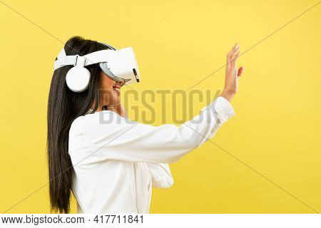 Black Asian Woman Wearing Vr Headset Over Yellow Background To Get Excite Experience Of Virtual Real