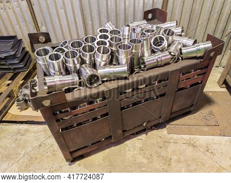 Shiny Steel Parts Overflowing Big Intermodal Steel Container Box On Factory Floor