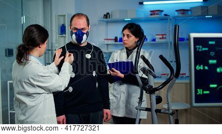 Scientist Researcher Preparing Man Patient For Endurance Test
