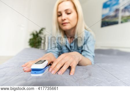 Woman Patient Using Medical Device Called Finger Pulse Oximeter. From Below, Close-up. Unrecognizabl