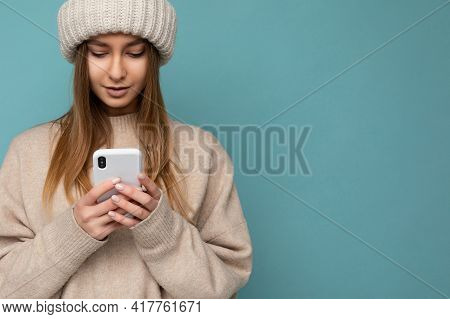 Closeup Portrait Photo Of Beautiful Young Blonde Woman Wearing Stylish Beige Warm Sweater And Knitte