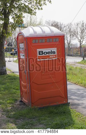 Sint Gillis Waas, Belgium, April 21, 2021, A Rented Mobile Orange Toilet For Workers At A Constructi
