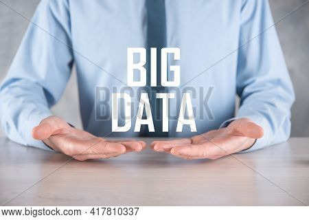 Businessman In A Suit On A Dark Background Holds The Inscription Big Data. Storage Network Online Se