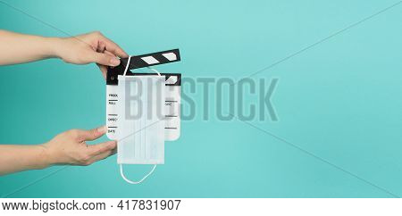 Fack Mask On Clapperboard And Hand Is Holding Clapper Board Or Movie Slate.it Is Used In Film Produc