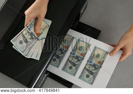 Counterfeiter Printing Dollar Banknotes At Grey Table, Top View. Fake Money Concept