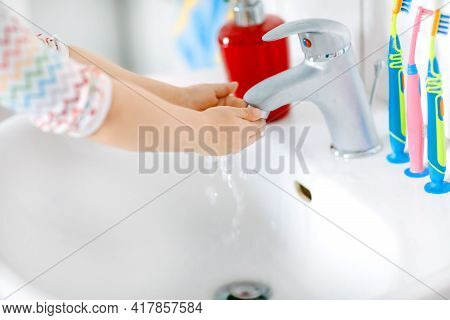 Closeup Of Little Toddler Girl Washing Hands With Soap And Water In Bathroom. Close Up Child Learnin
