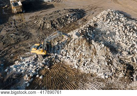 Recycling Concrete And Construction Waste From Demolition. Excavator At Landfill Of The Disposa. Reu