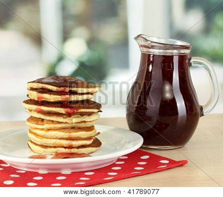 หวาน pancakes บนแผ่นกับแยมบนโต๊ะในห้องครัว
