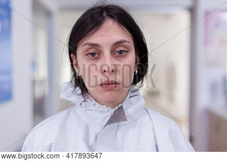 Close Up Of Exhausted Nurse In Office Looking On Camera Wearing Ppe Suit
