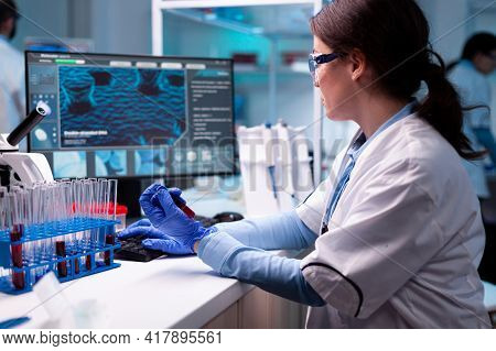Scientist Typing On Laptop Holding Vacutainer Blood Healthcare Chemistry