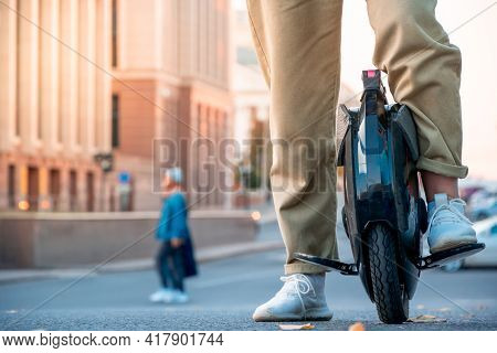 The Legs Of A Young Woman Ready To Ride An Electric Unicycle, Abbreviated Euc, Against The Backgroun