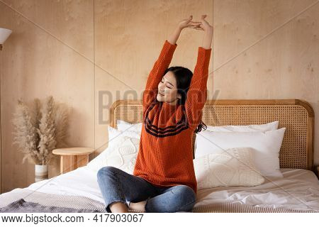 Portrait Of A Beautiful Asian Woman Wearing A Sweater Over The Bed In Winter. She Wakes Up In The Mo