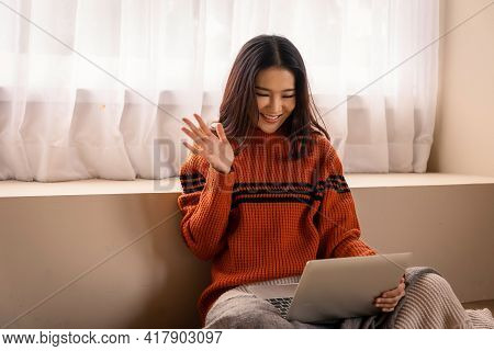 Portrait Of A Beautiful Young Asian Woman Making Facetime Video Calling With A Laptop. She Making A 