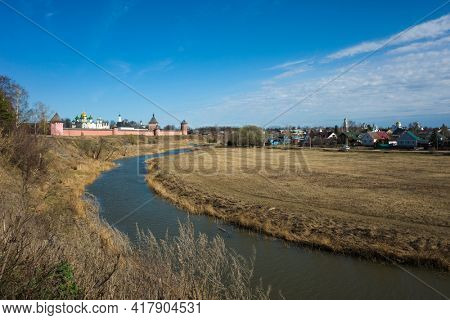 Suzdal view with river Kamenka, Saint Euthymius monastery red wall with towers, residential area and central Russia nature in spring in middle april, Golden Ring of Russia