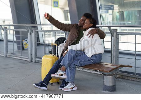 Happy Smiling Couple Of Tourists Taking Selfie Outdoors Airport Terminal Wait For Bus Or Taxi After 
