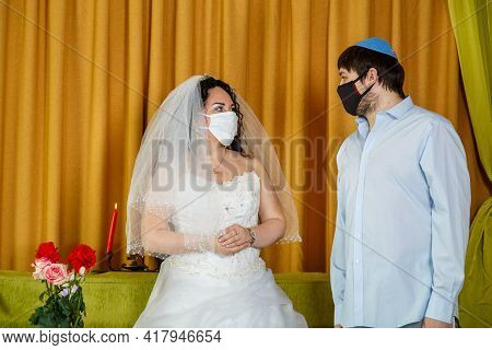 During The Chupa Ceremony In The Synagogue, The Masked Jewish Bride And Groom Stand Side By Side. Ho