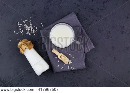Rice Milk In A Glass Mug And A Bottle On A Dark Grey Background. Vegetable Milk. Vegan Lactose Free.