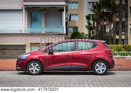 Alanya, Turkey - April 12 2021:  Red Renault Clio   Is Parked  On The Street On A Warm Summer Day Ag