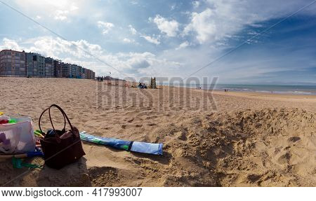 Point Of View On The Beach Of Koksijde In Belgium On A Sunny Springday With Some Beachtoys And Handb