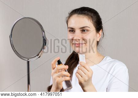 A 25-year-old Woman Holds A Face And Neck Tonic And A Cotton Pad. Anti-wrinkle Skin Care, Vitamins A