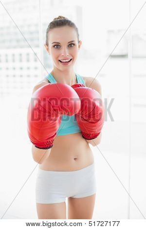 Sporty happy woman boxing in bright room