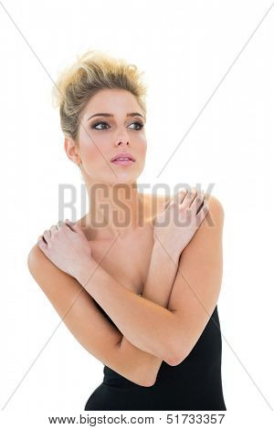 Sexy blonde model holding her shoulders on white background