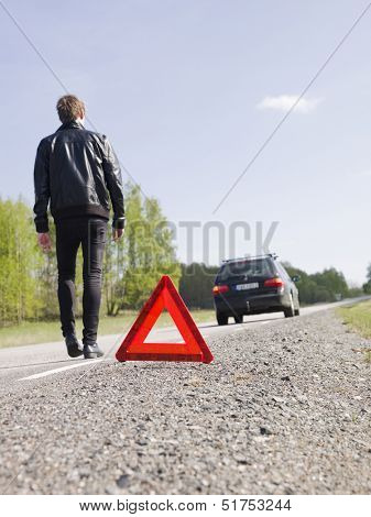 Warning triangle in front of a car breakdown