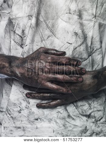 Very dirty hands in front of a dirty shirt