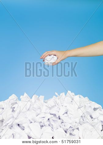 Hand with white paper on blue background