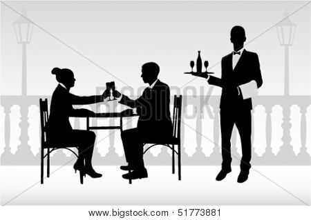 couple in restaurant holding glasses and waiter serving them