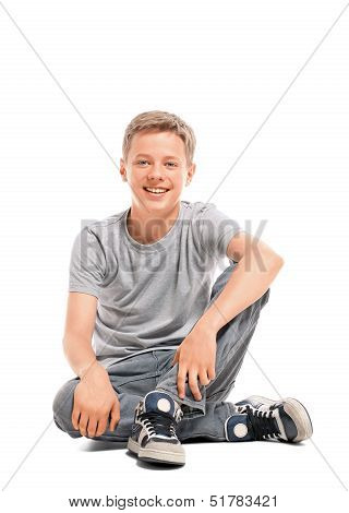 Happy teenage boy sitting on the floor