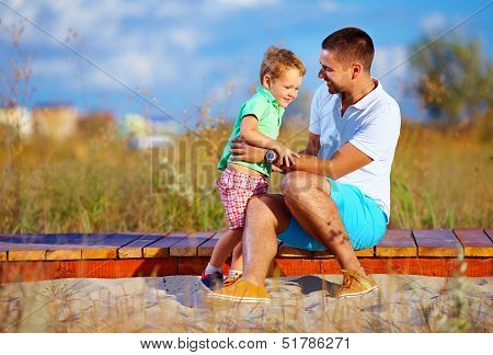 Father And Son Having Fun Playing At Summer Field