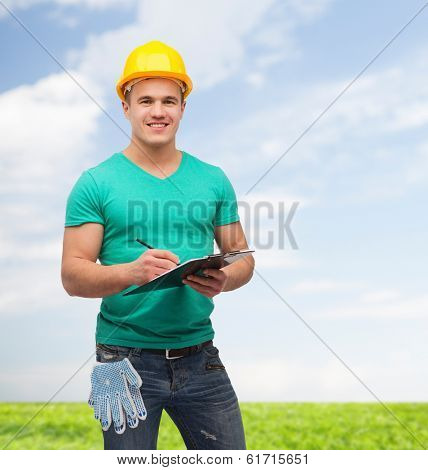 repair, construction and maintenance concept - smiling man in helmet with clipboard