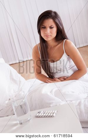 Woman With Stomach Pains In Bed
