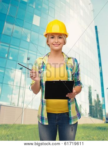 repair, construction and maintenance concept - smiling woman in helmet with clipboard