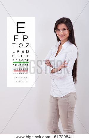 Woman Pointing Standing Nex To An Eye Chart